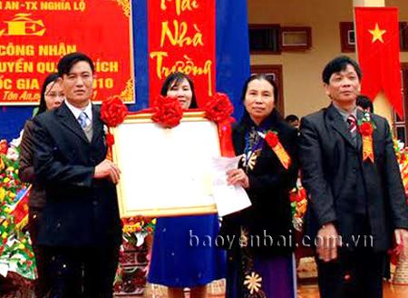 Cô giáo Trương Thị Nụ (thứ 2, phải sang) cùng Ban giám hiệu nhà trường đón Bằng công nhận Trường THCS Nguyễn Quang Bích đạt chuẩn quốc gia.